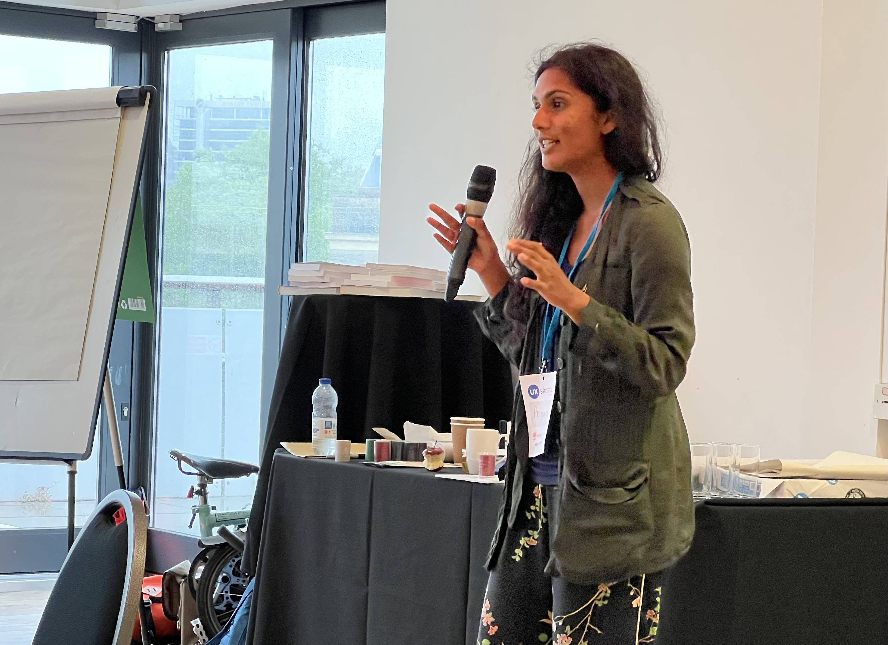 Priyanca D’Souza presenting at UXBristol with a microphone in her hand